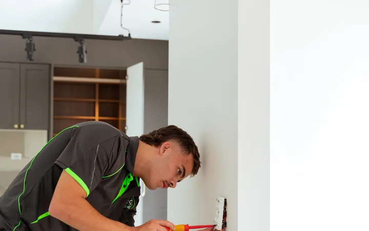 Electrician marking out a wall for a new outlet