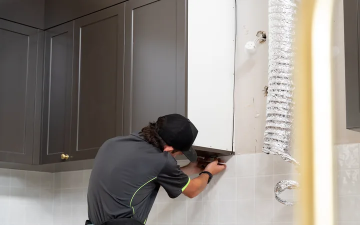Electrician fitting a powerpoint at a benchtop