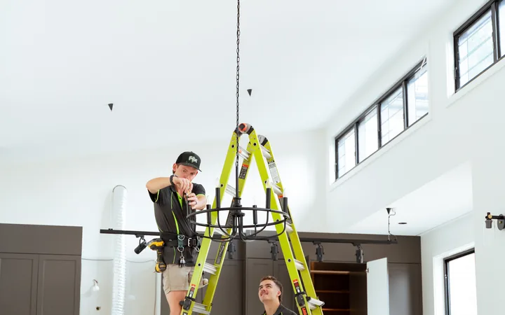 Electricians installing lighting during fitout
