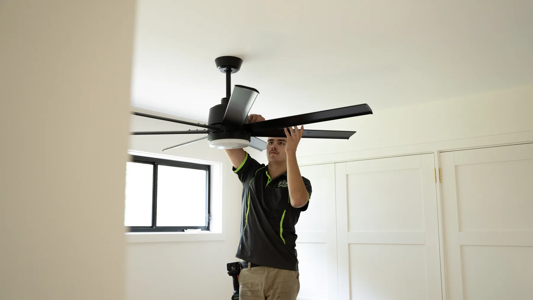 Fix Electrical electrician fitting the blades to a new ceiling fan