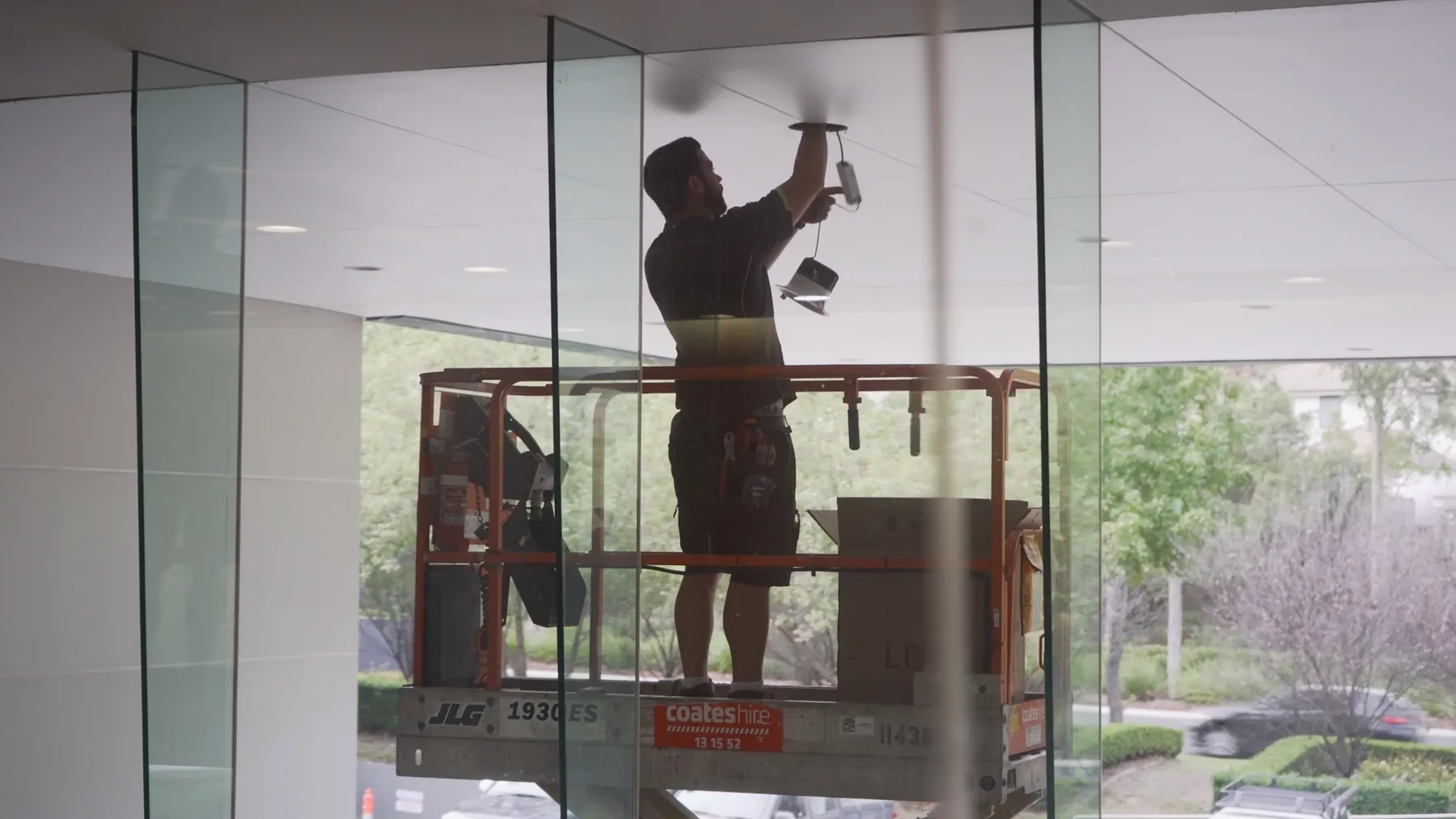 Fix Electrical electrician installing lighting from a scissor lift in a commercial office