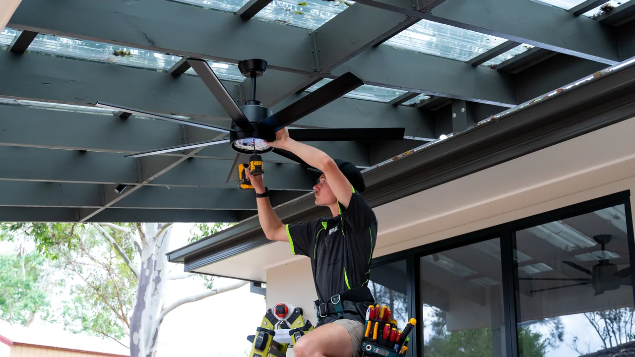 Electrician installing an outdoor pergola fan
