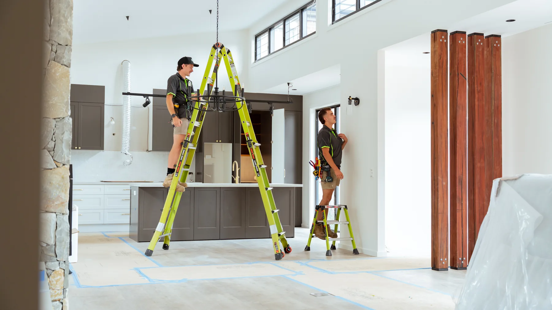 Electricians installing a light fitting in a new kitchen