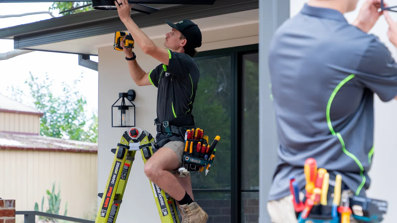 Electricians installing exterior lighting