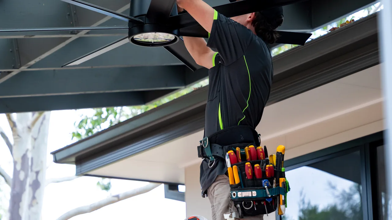 Electrician working overhead on a patio roof