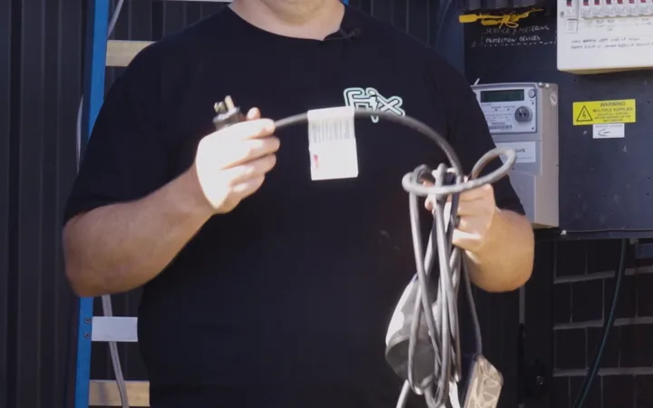 Electrician checking the supply at the meter box before installing an EV charger