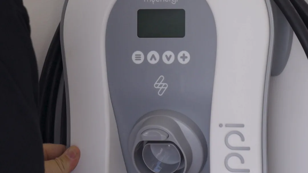 Electrician mounting an EV charger to a wall