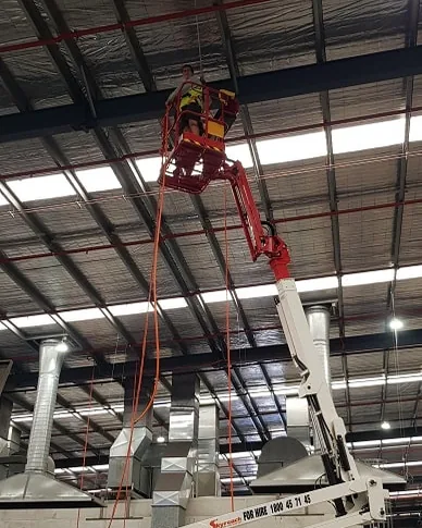 Fix Electrical electrician working at height from a boom lift in a factory