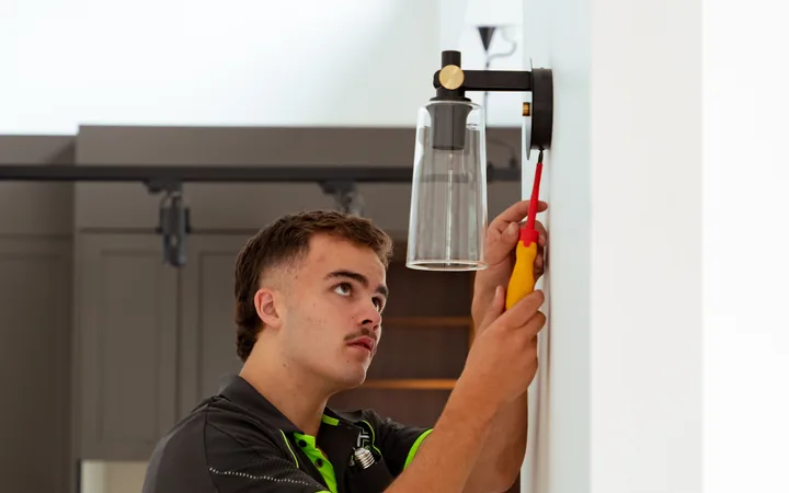 Electrician inspecting a light fitting