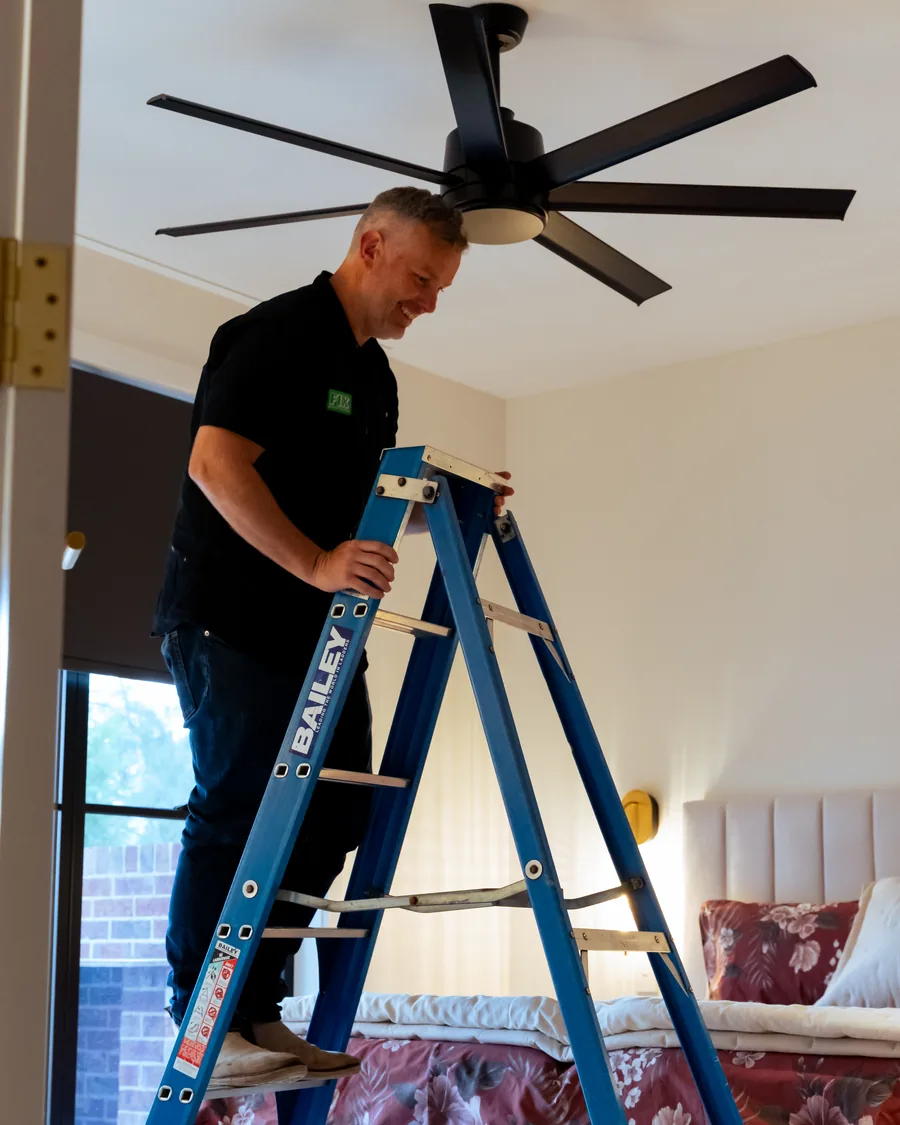 Electrician installing a bedroom ceiling fan