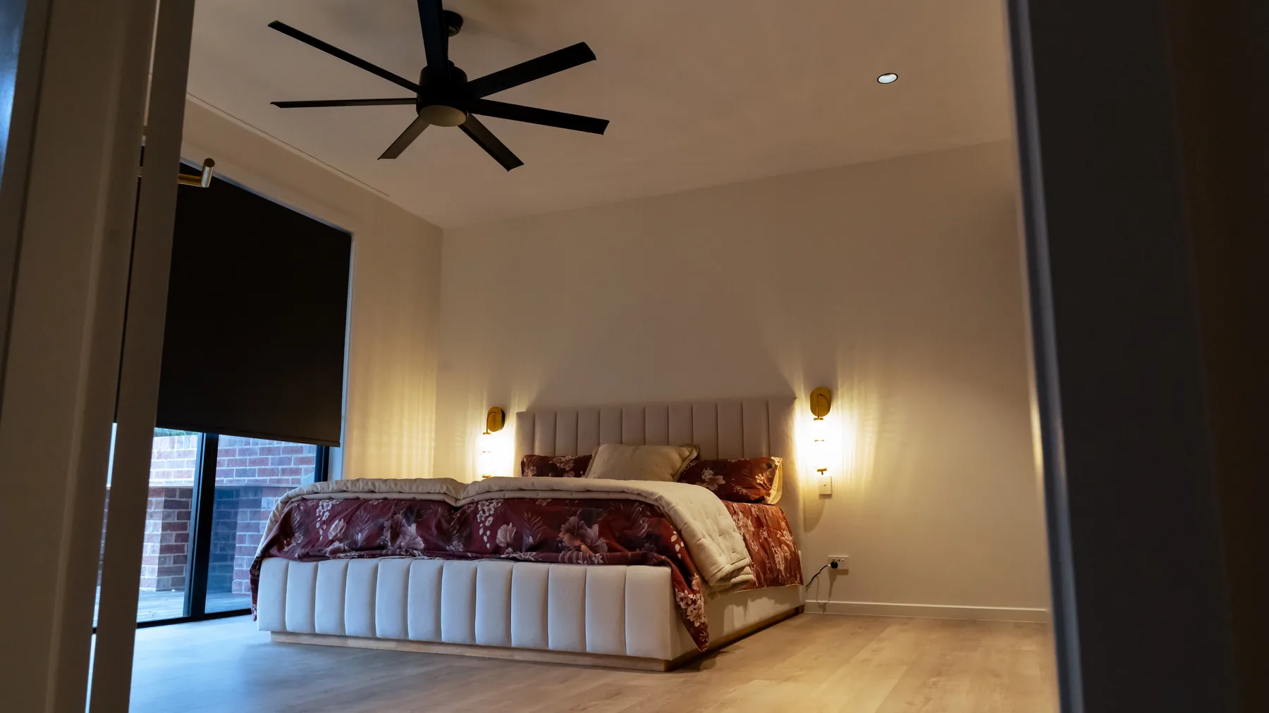 Bedroom with ceiling fan and wall lighting