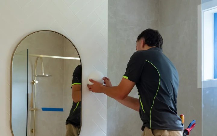 Electrician installing bathroom vanity lighting